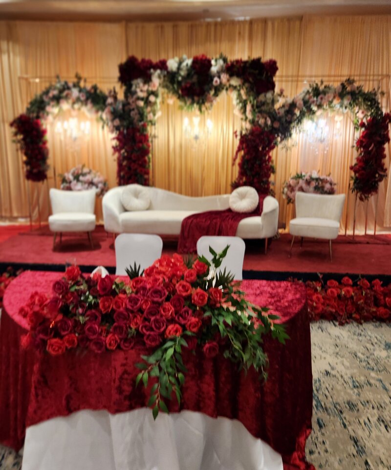 Burgundy and gold wedding reception stage deep red roses cascading greenery Ohio