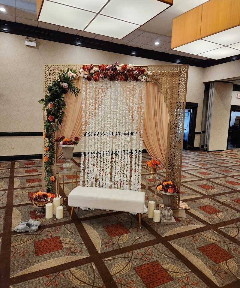 Gold laser-cut panels with cascading wisteria and autumn florals Haldi ceremony decor Ohio