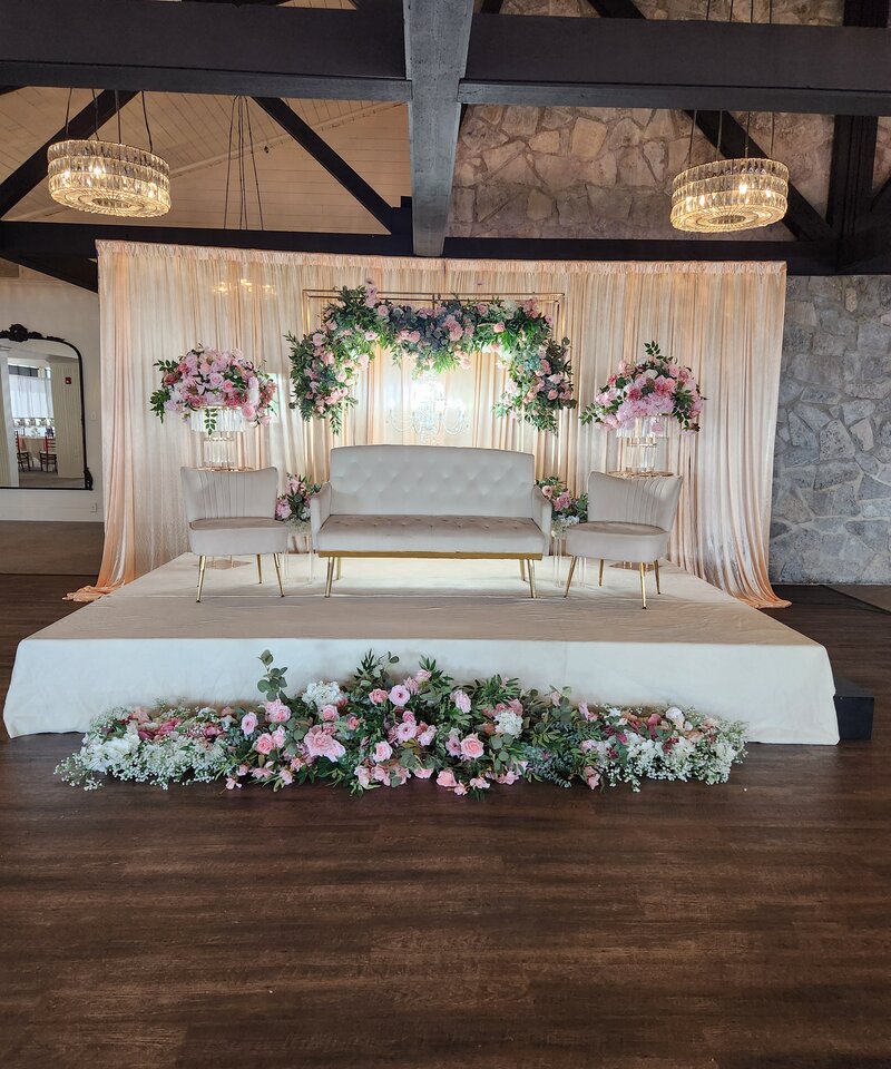 Blush pink and gold wedding reception stage with geometric frame and rose garlands Ohio