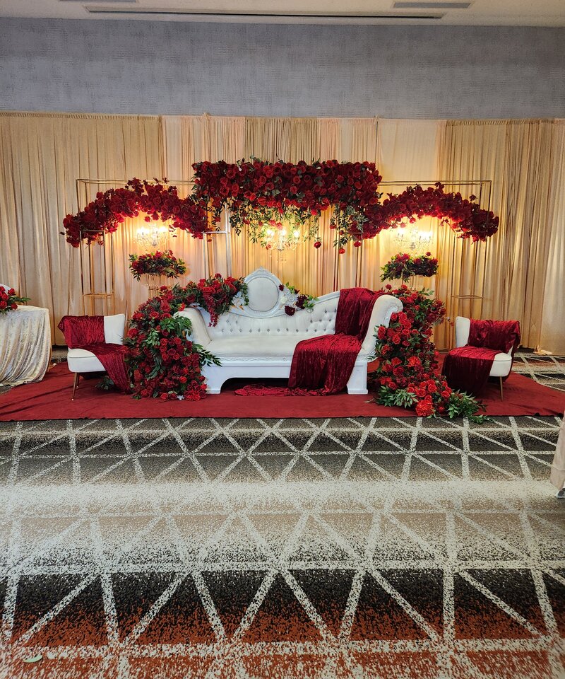 Burgundy red and gold Nikkah wedding stage with rose cascade and Victorian sofa Perrysburg Ohio