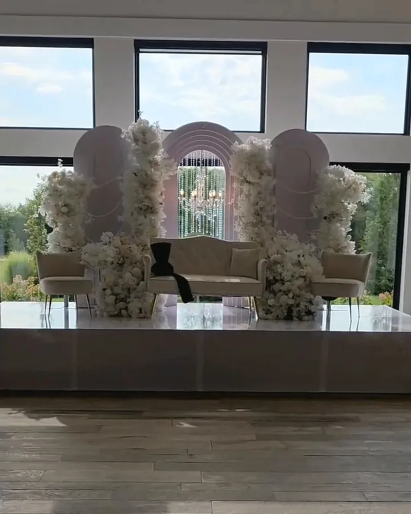 White floral ceremony stage with arched panels by Events By Maryam
