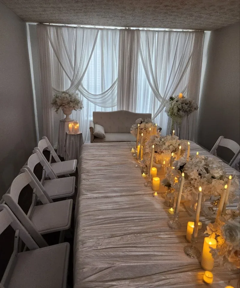 White candlelight stage with draped backdrop by Events By Maryam